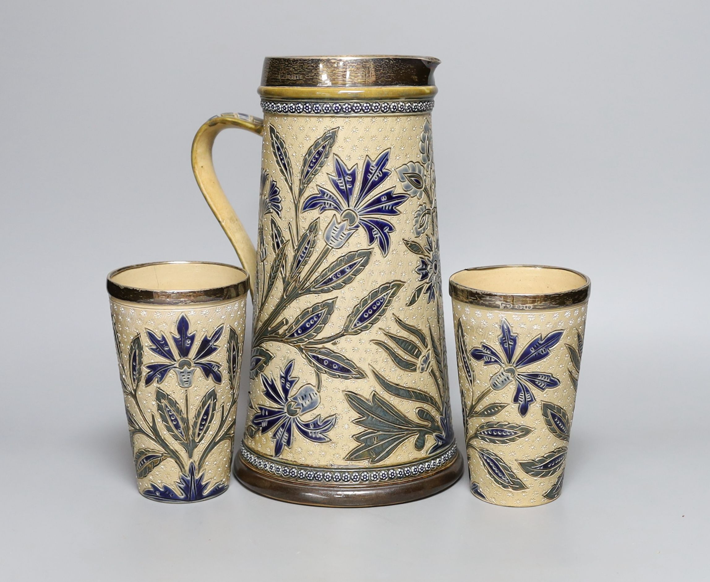 A silver mounted Doulton Lambeth jug by Louisa J Davis, 26.5cm tall, and a pair of matching beakers